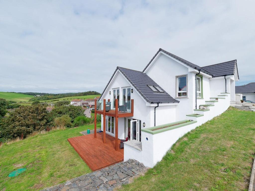una imagen de una casa en una colina en Seaviews And Hot Tub At Admirals Anchor, en Portpatrick