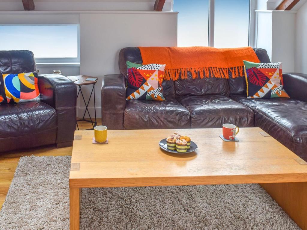a living room with a couch and a coffee table at First Floor The Hayloft in Porthcurno