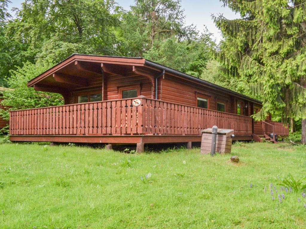 a log cabin with a large deck in a field at Red Kite Lodge - Uk37417 in Legbourne