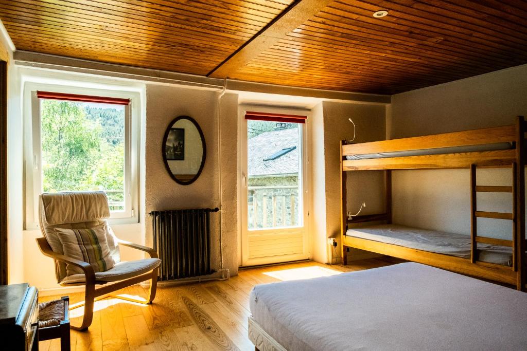 ein Schlafzimmer mit einem Etagenbett und einem Stuhl in der Unterkunft Maison Sarda in Formiguères