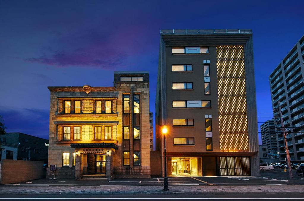 two tall buildings in a city at night at OMO5 Otaru by Hoshino Resorts in Otaru