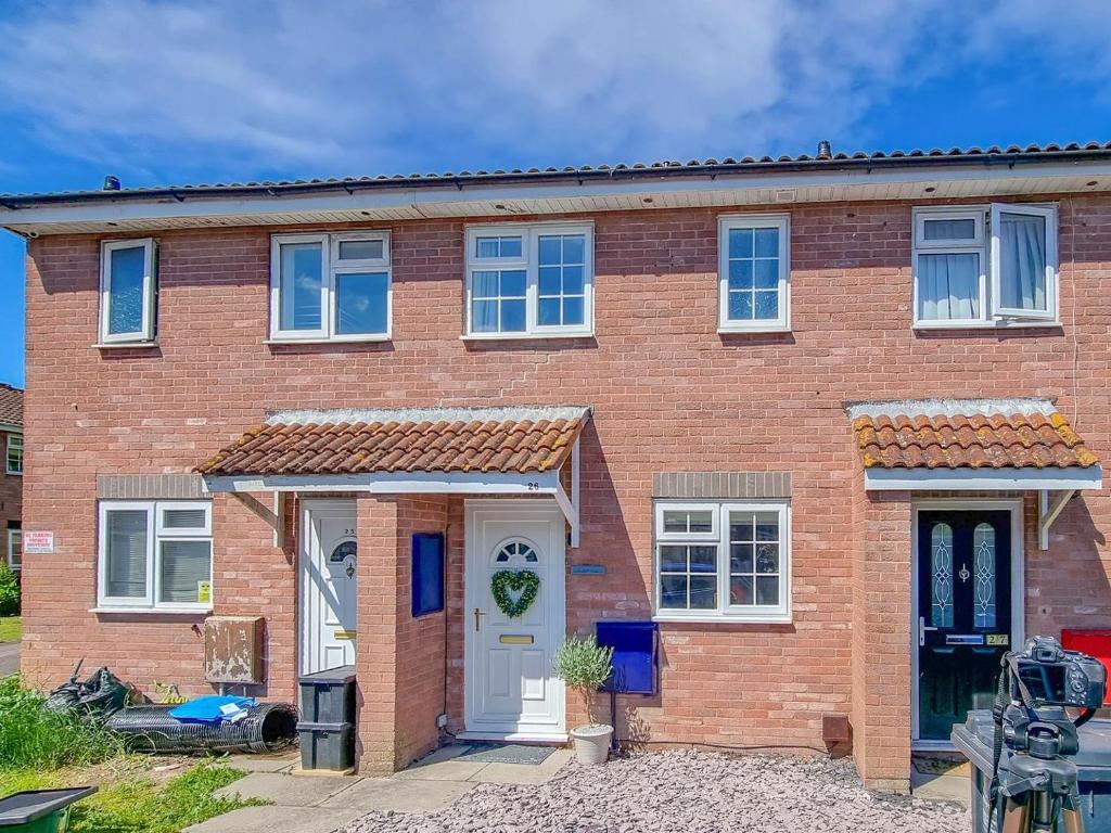 a red brick house with a white door at Seashell House in Burnham on Sea