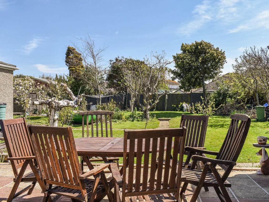 a wooden table and four chairs around a wooden table at Byeways - Railway Carriage in Selsey