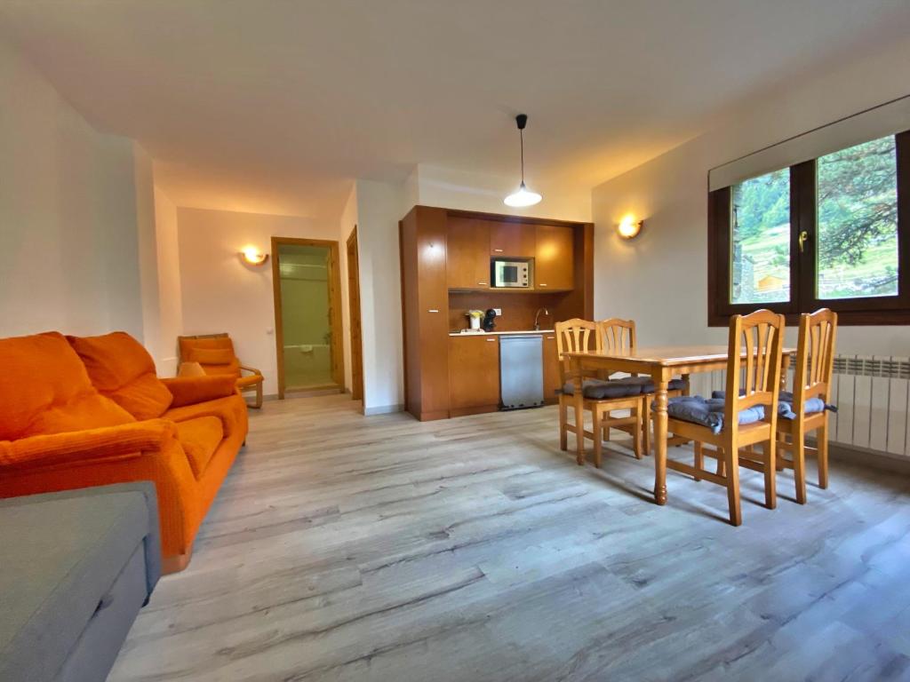 een woonkamer met een bank en een tafel en stoelen bij Pleta de Peu del Riu hasta 4 personas in Canillo