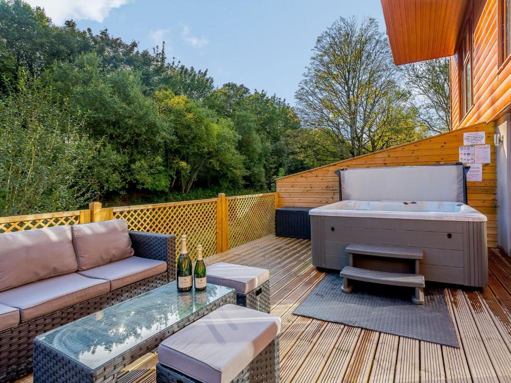 patio con sofá y terraza con bañera de hidromasaje. en Waterside Lodge Three - Uk33350 en Southowram
