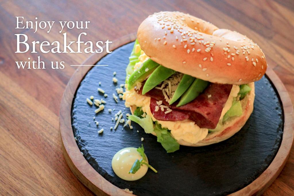 a sandwich on a blue plate on a table at Grandmas Plus Hotel Seminyak in Seminyak