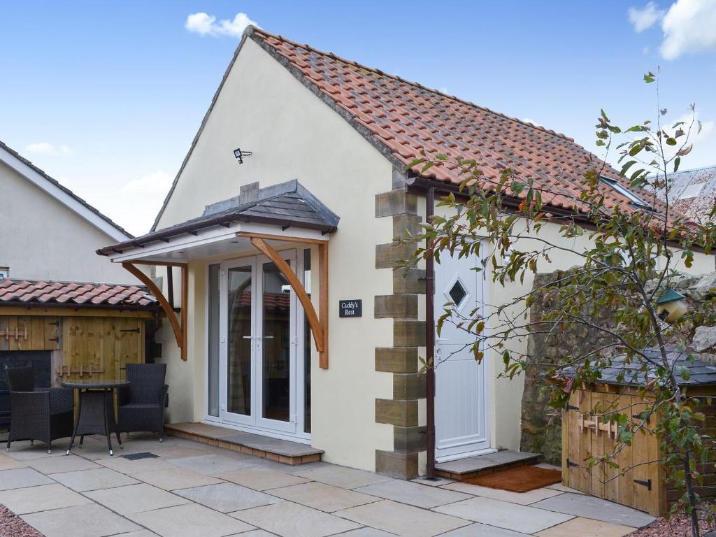 a detached cottage with a patio and entry door at Cuddys Rest in Belford