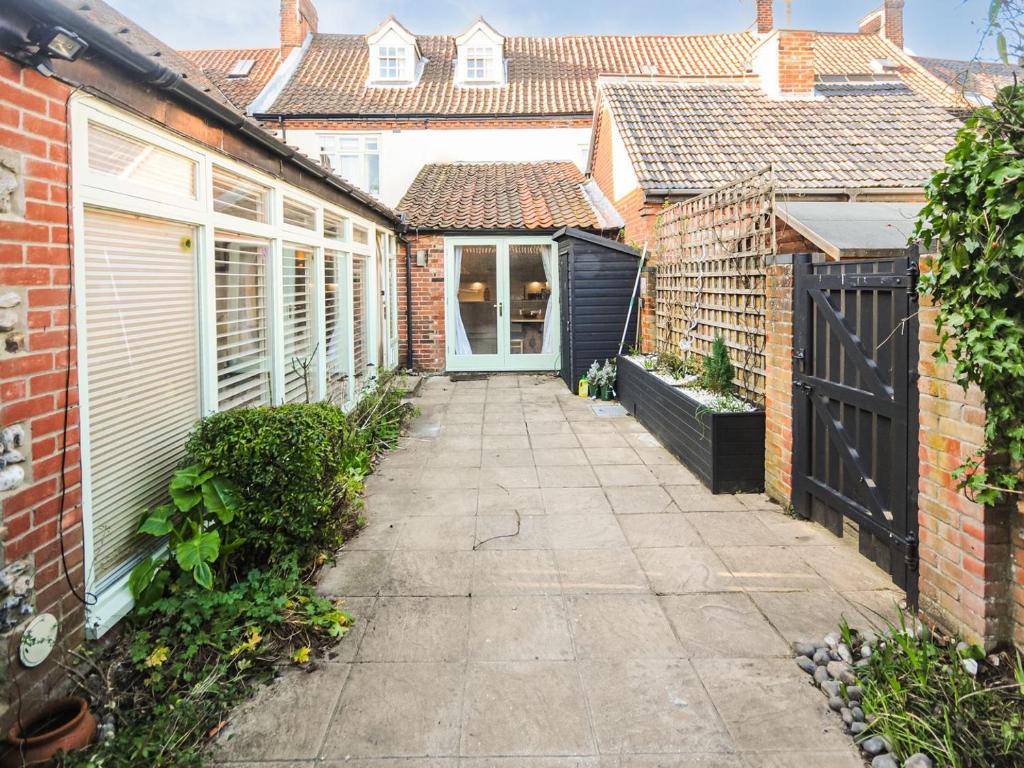 a courtyard of a house with a driveway at Peggs Yard in Aylsham