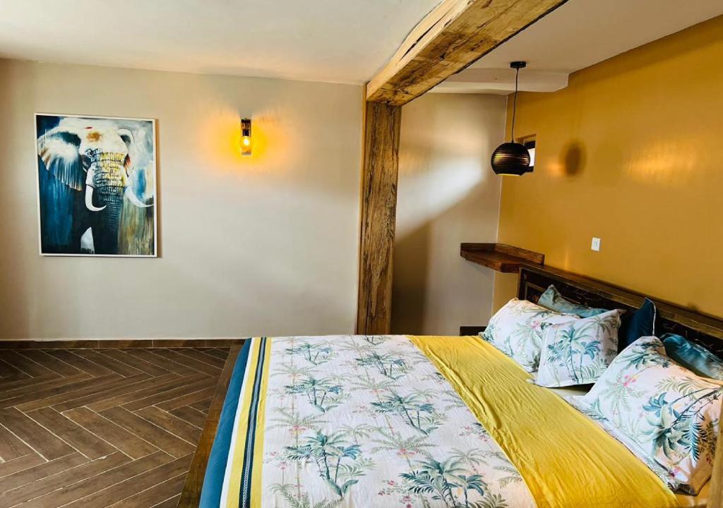 a bedroom with a bed and a picture of an elephant at The Forest Resort - Lweza in Makindye