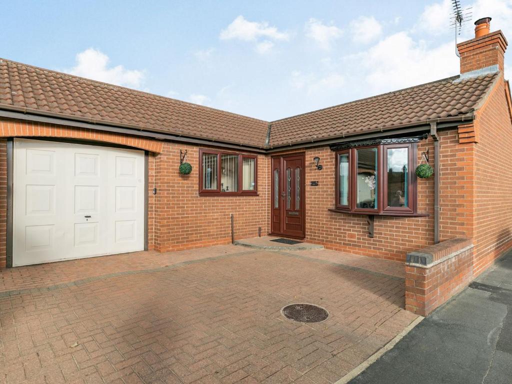 a brick house with a white garage at Berwood Cottage in Epworth