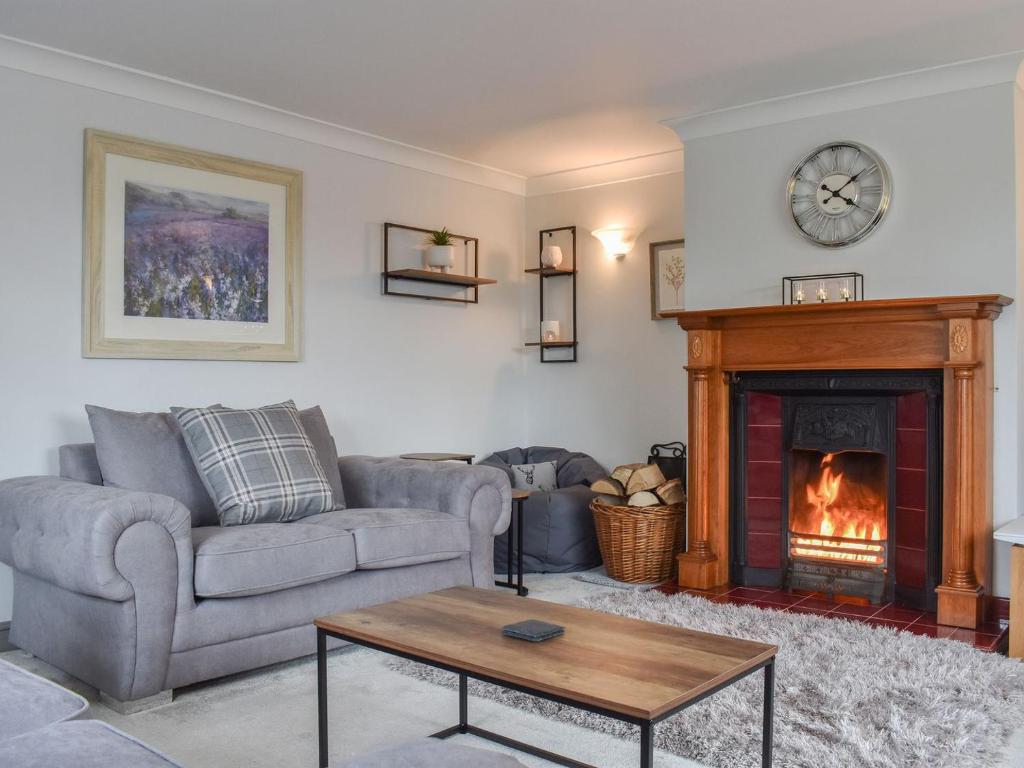 a living room with a couch and a fireplace at Brookside House in Pickering