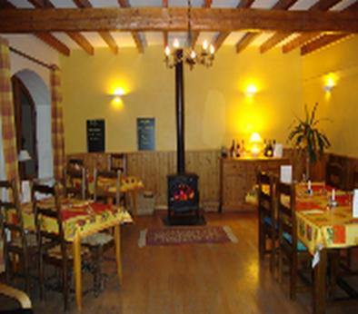 a room with tables and chairs and a fire place at Hotel Bermond in Saint-Julien-en-Beauchêne