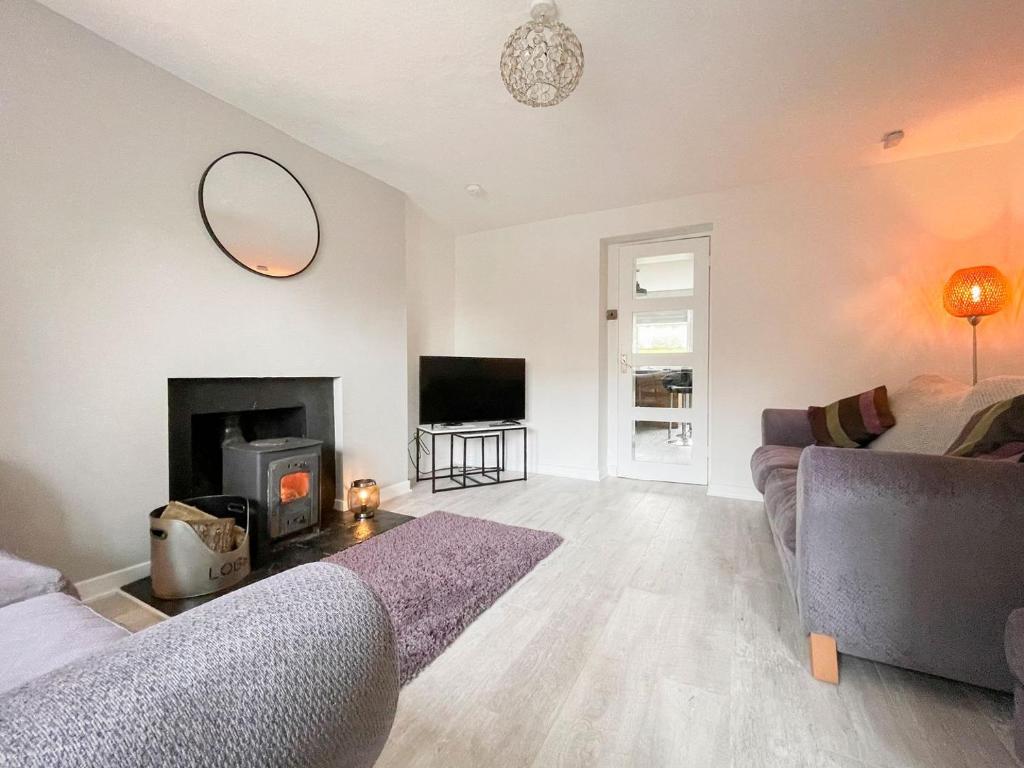 a living room with a couch and a fireplace at Academy Street Cottage in Tain