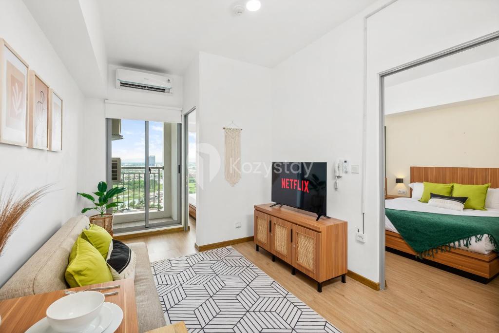 a living room with a bed and a couch at Eunoia by Kozystay - Serpong in Tangerang