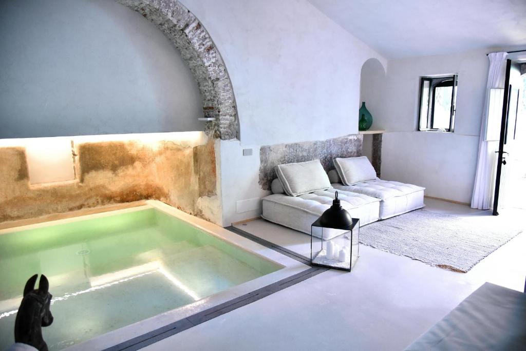 Castello di San Marco Charming Hotel & SPA في كالاتابيانو: حوض استحمام في غرفة معيشة مع أريكة