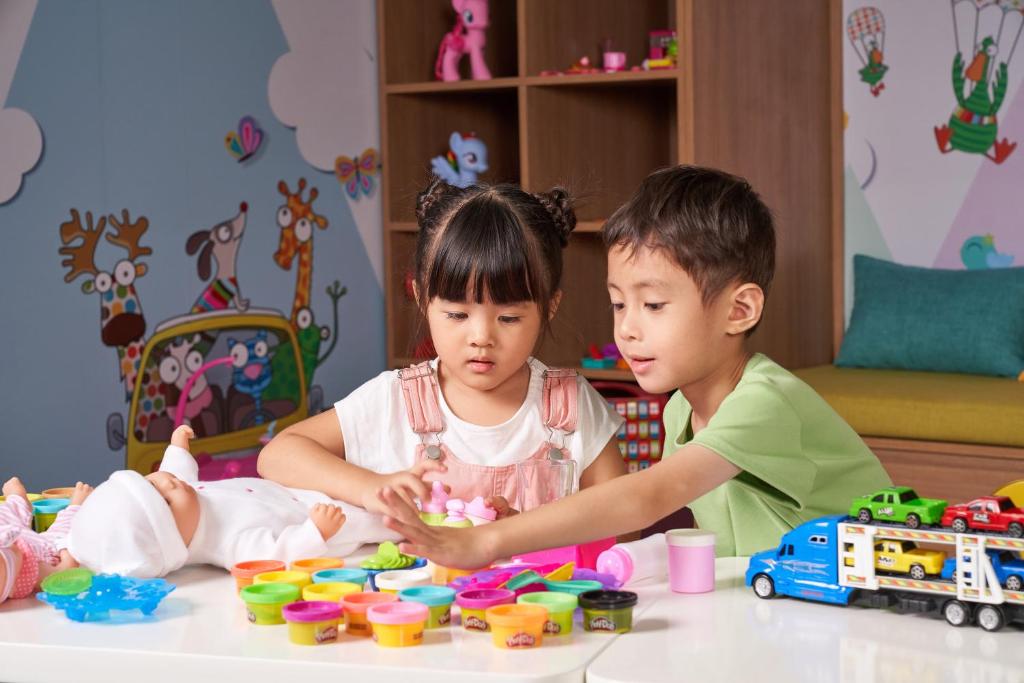 a boy and a girl playing with toys at a table at Holiday Inn & Suites Saigon Airport by IHG in Ho Chi Minh City