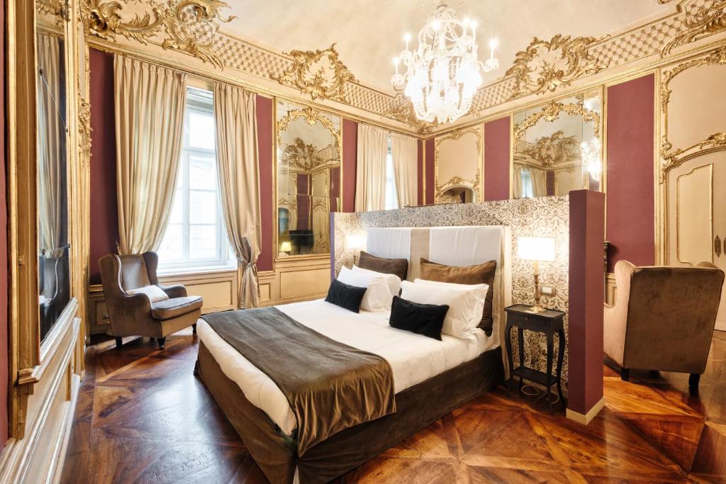 a bedroom with a large bed and a chandelier at Palazzo Del Carretto-Art Apartments and Guesthouse in Turin