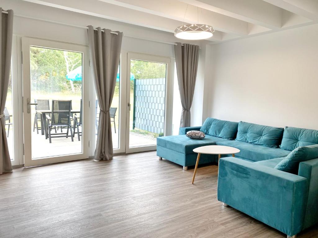 ein Wohnzimmer mit einem blauen Sofa und einem Tisch in der Unterkunft Ferienwohnung "Jolle" in Binz