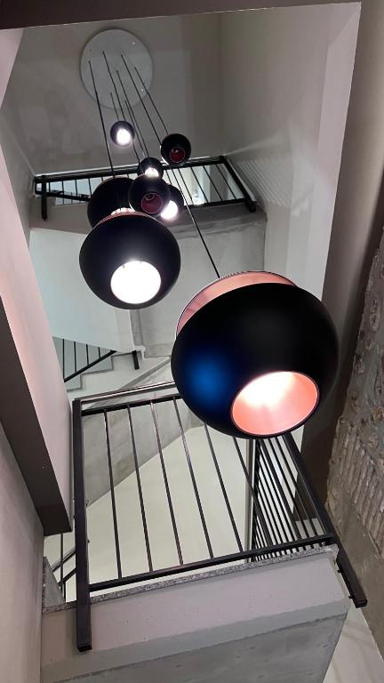 a staircase with three lights and a black chair at Hotel Centre Reus in Reus