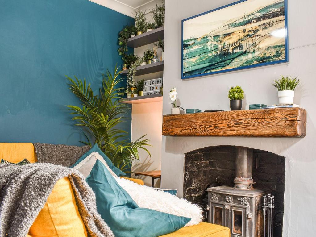 a living room with a couch and a fireplace at Stonesthrow Townhouse in Leek