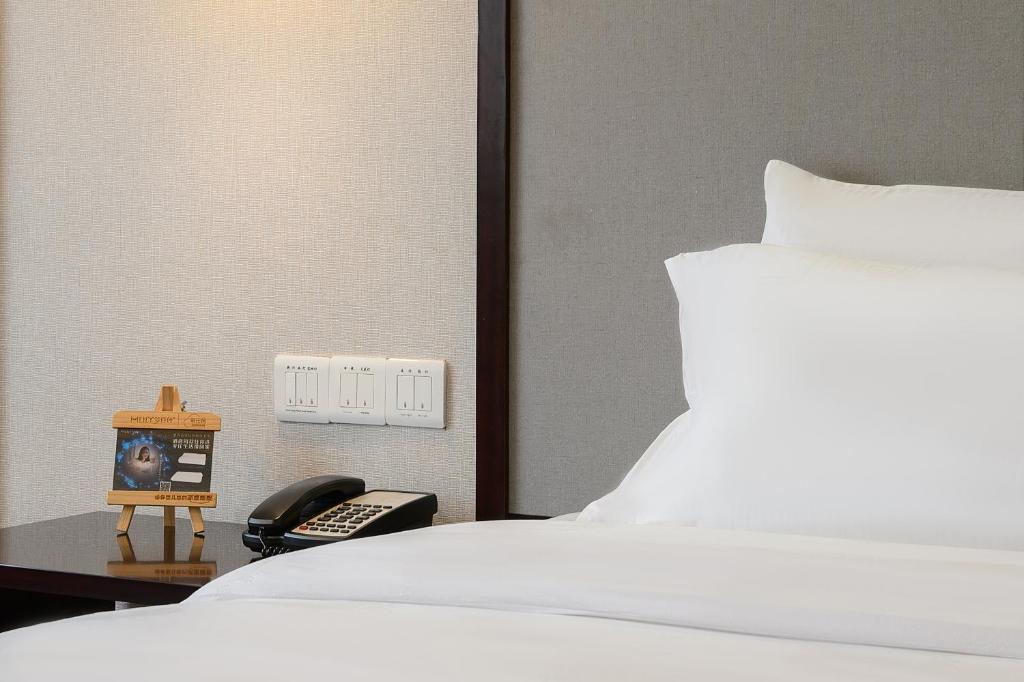 Postel nebo postele na pokoji v ubytování Foshan Rezen Select Pasonda Hotel