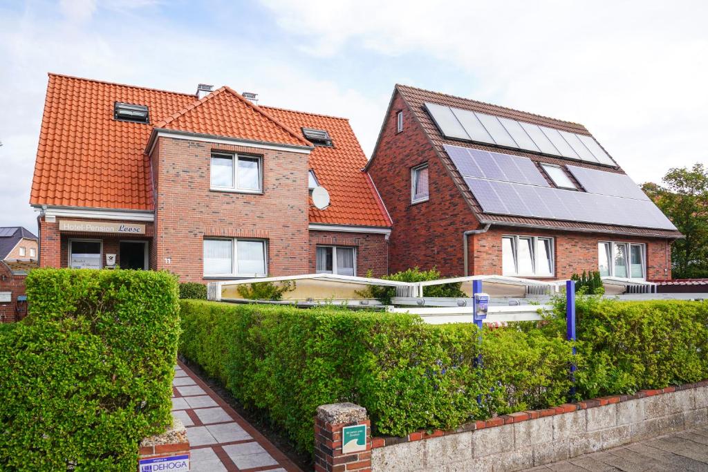 a house with a solar panel on top of it at Hotel Pension Loose in Borkum