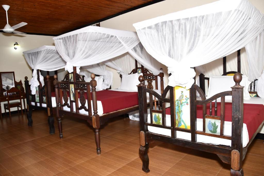 a group of four beds in a room at Minara Miwili - Forodhani Park in Zanzibar City
