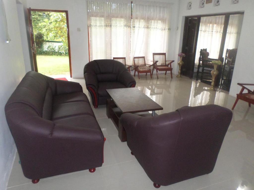 Sala de estar con 2 sofás y mesa de centro en Grand Villa, en Mirissa