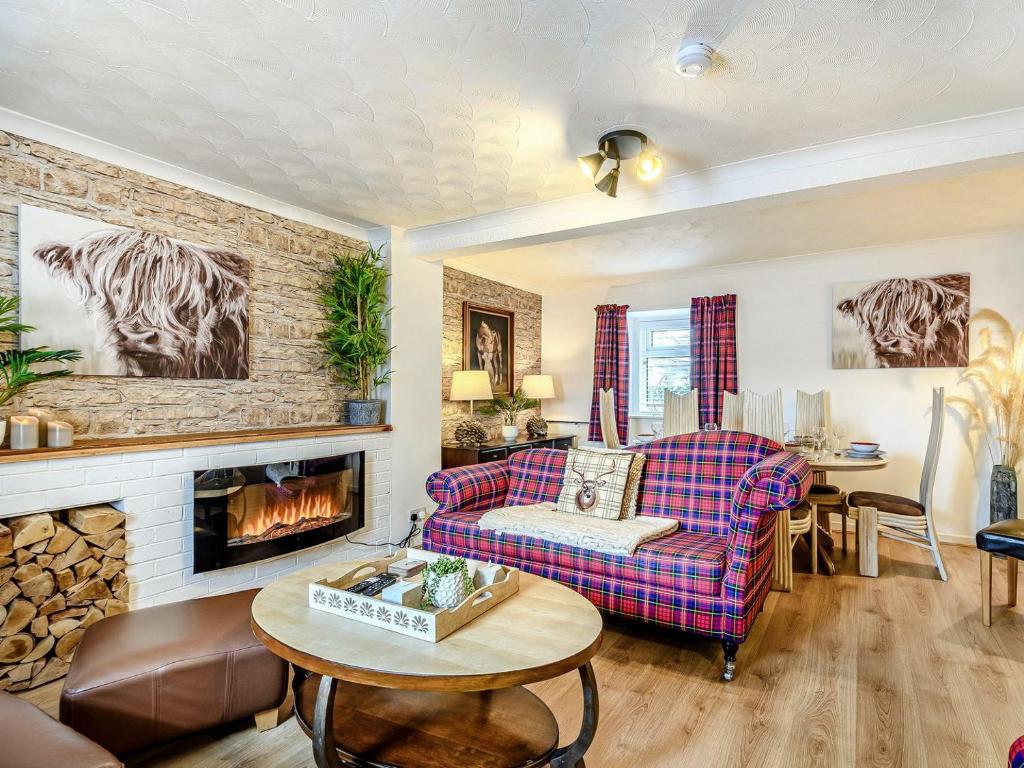 a living room with a couch and a fireplace at Amazing Cottage In Girvan With 4 Bedrooms And Wifi in Girvan