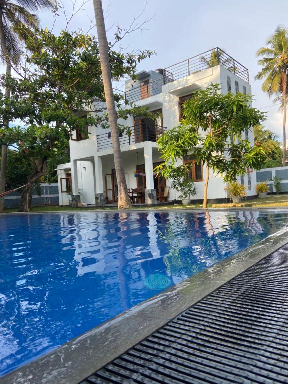 une villa avec une piscine en face d'une maison dans l'établissement The Pearl, à Marawila