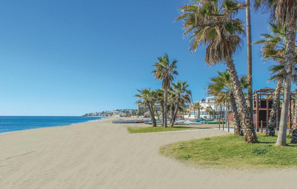 a sandy beach with palm trees and the ocean at CT 138 - La Cala Boulevard - Apartement I in La Cala de Mijas