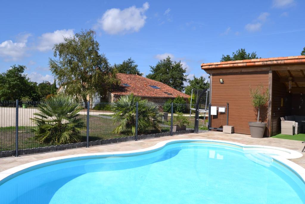 a swimming pool in front of a house at Logis de La Bénétière in Treize-Vents