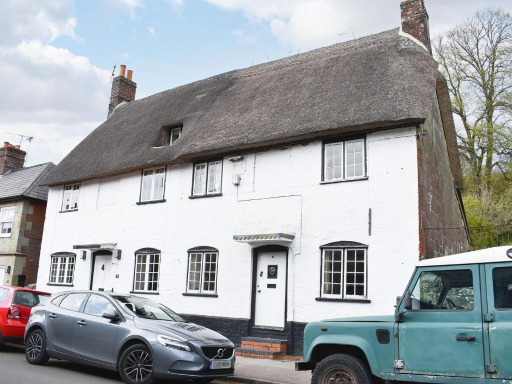 a white house with cars parked in front of it at St James Cottage in Shaftesbury