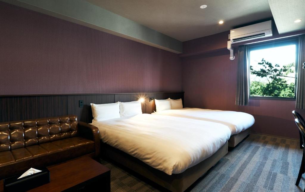 a bedroom with two beds and a couch at Rakuten STAY Kokura Station Standard Twin Room with counter table in Kitakyushu