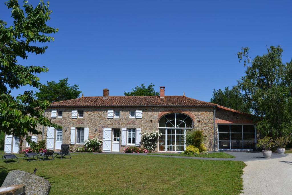 una gran casa de ladrillo con césped delante en Logis de La Bénétière, en Treize-Vents