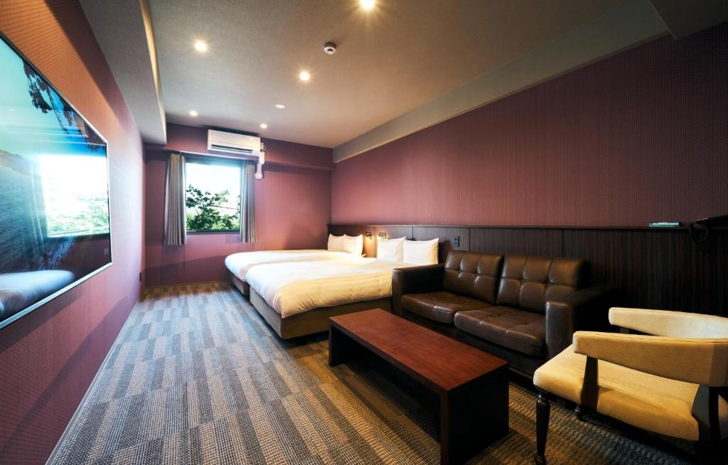 北九州市にあるRakuten STAY 小倉駅前 スタンダードツインのベッドとソファ付きのホテルルーム