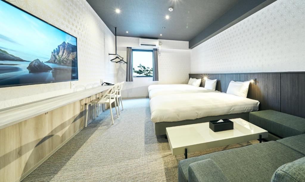 um quarto de hotel com uma cama e uma televisão em Rakuten STAY Kokura Station Standard Triple Room em Kitakyushu