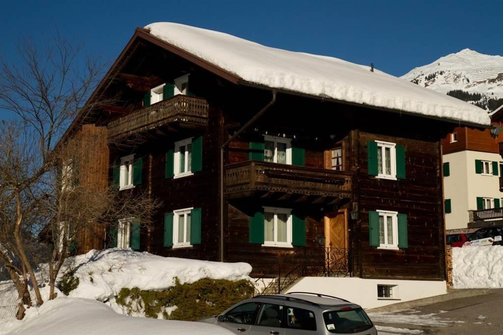 a snow covered house with a car parked in front of it at Haus Danna in Sankt Gallenkirch
