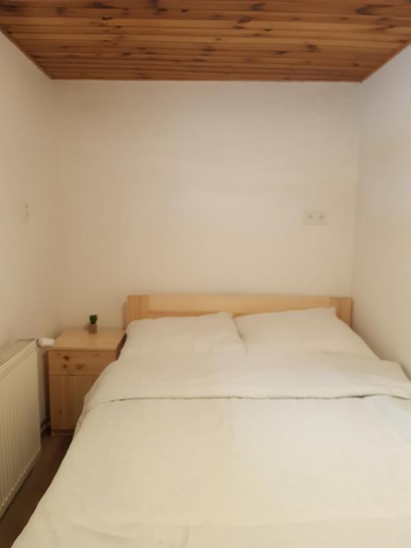 1 Schlafzimmer mit 2 weißen Betten und einer Holzdecke in der Unterkunft Ubytovani u Nadii in Železný Brod