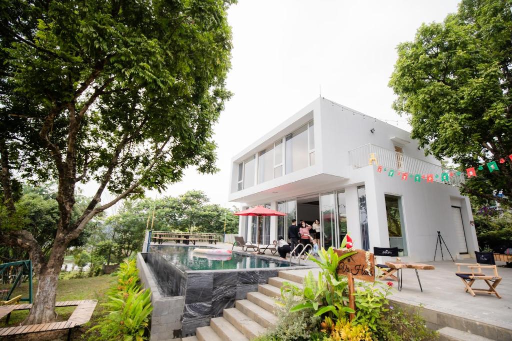 una casa blanca con piscina frente a ella en LaVa Haus Homestay Hòa Bình - Venuestay, en Hòa Bình