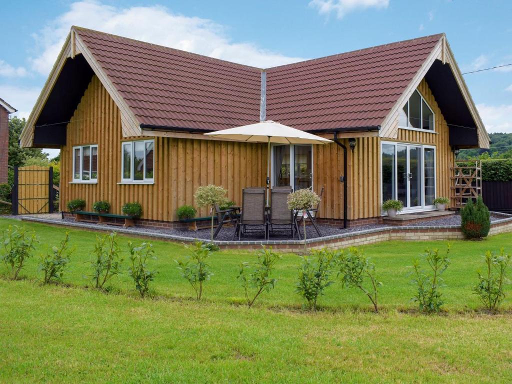 a wooden house with a pitched roof at Bumble Lodge in Llynclys