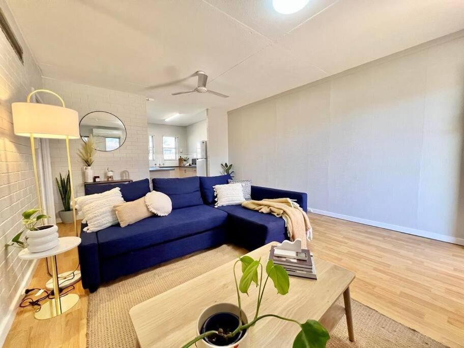 uma sala de estar com um sofá azul e uma mesa em Tastefully renovated - 3 bedroom apartment em South Hedland
