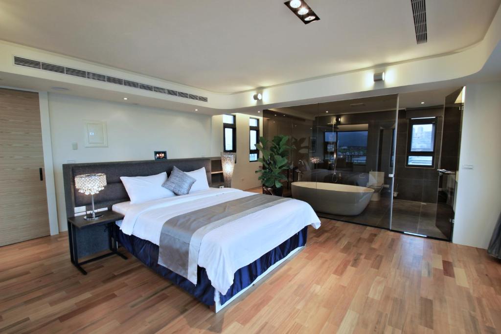 a bedroom with a large bed and a bath tub at Han-Shian Boutique B&amp;B in Dongshan