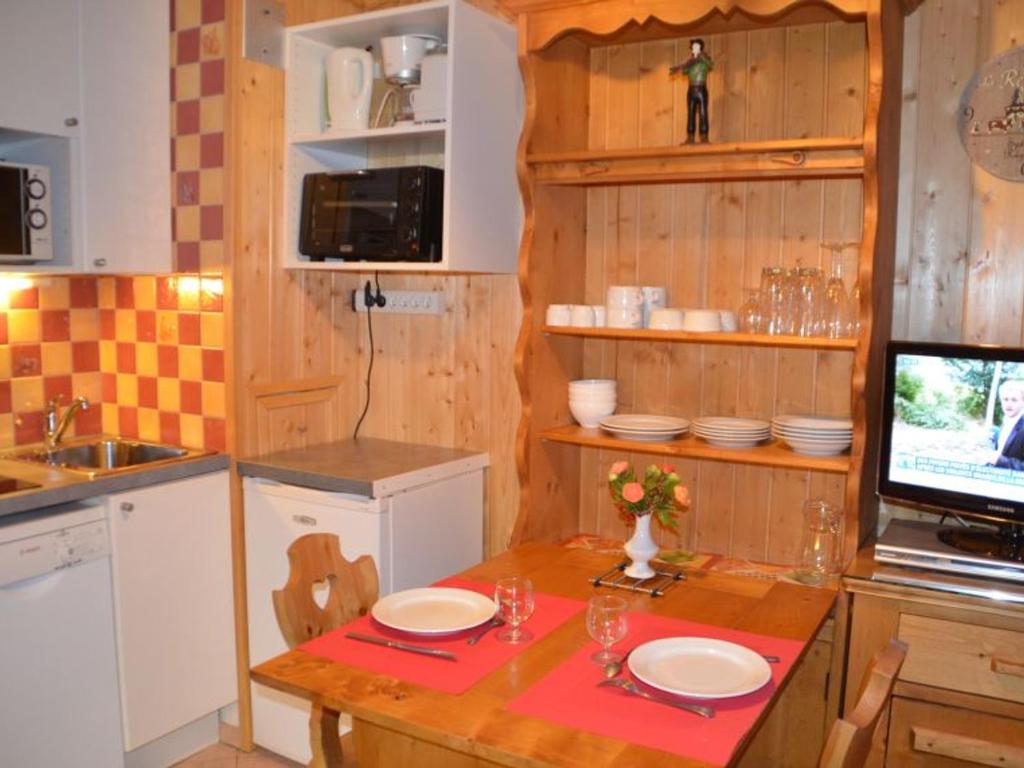 eine Küche mit einem Tisch und einem TV in der Unterkunft Studio Les Menuires, 1 pièce, 2 personnes - FR-1-452-11 in Les Menuires