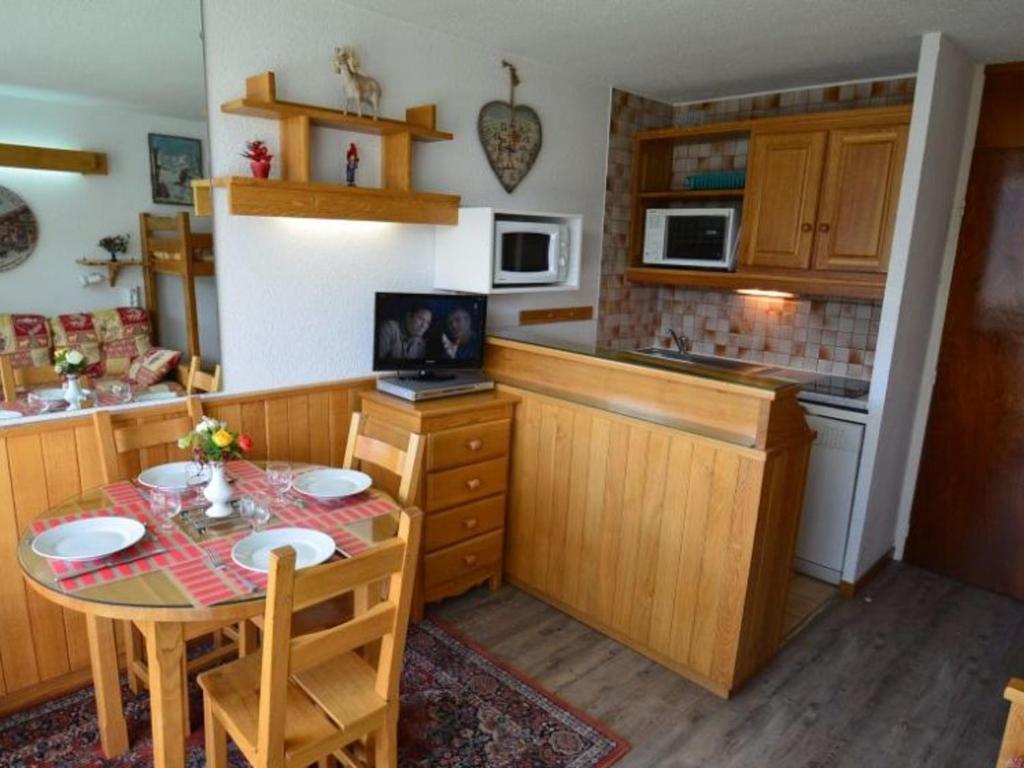 a small kitchen with a table and a table and chairs at Studio Les Menuires, 1 pièce, 3 personnes - FR-1-452-103 in Les Menuires