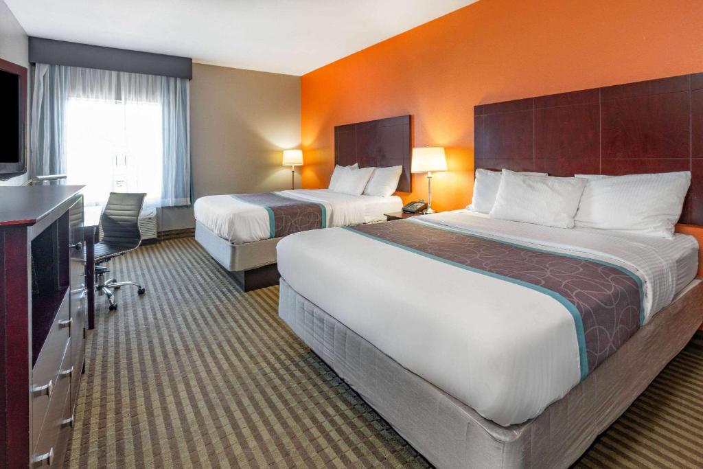 a hotel room with two beds and a television at La Quinta by Wyndham Houston IAH Bush Intl Airport E in Humble