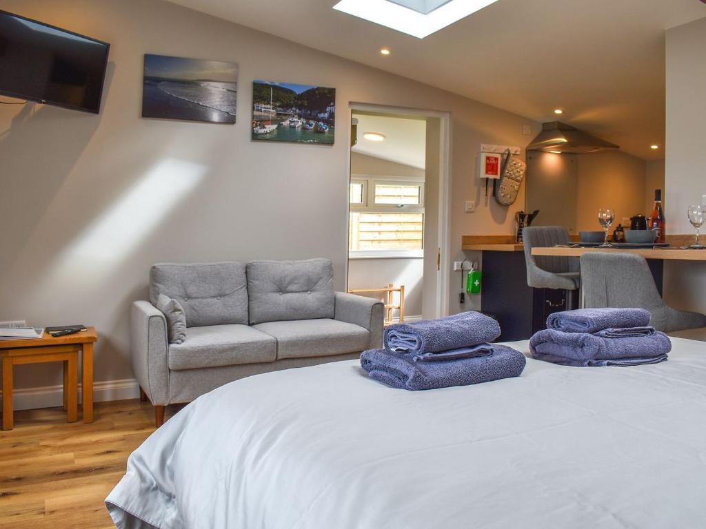 a bedroom with a bed with two blue towels on it at Durcombe Water Annexe in Barbrook