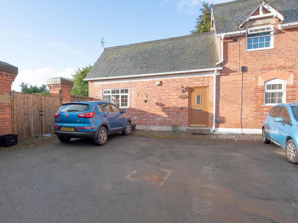 two cars parked in front of a brick house at The Coach House in Oswestry