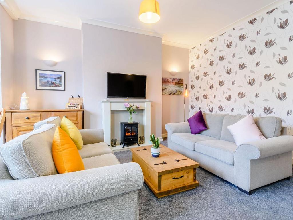 uma sala de estar com dois sofás e uma lareira em Buoy On The Bay em Bridlington