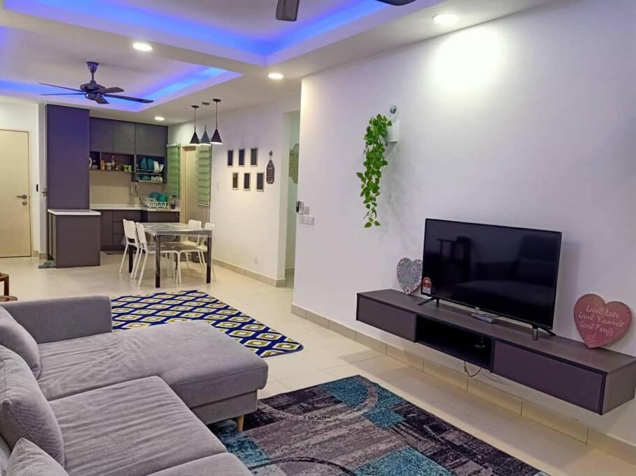 a living room with a couch and a flat screen tv at Debayu Homestay with Free Parking at Setia Alam in Shah Alam